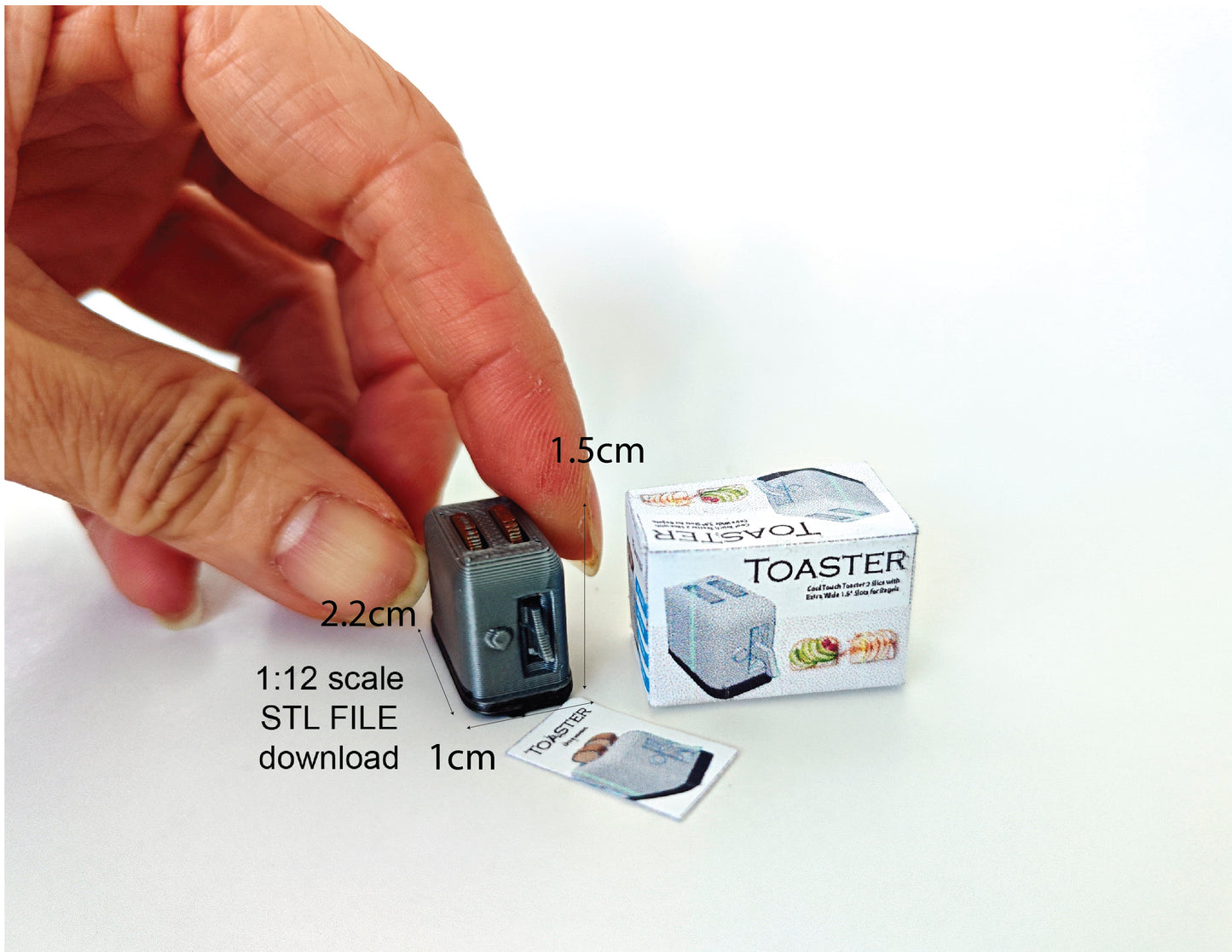 A 3D-printable STL file of a 1:12 scale miniature toaster, featuring detailed slots and buttons for a realistic dollhouse kitchen appliance