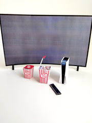 Miniature paper craft TV, game console, remote, and two popcorn boxes.
