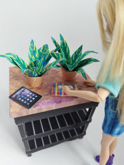 Two green and yellow patterned mini potted plants on a dollhouse table.