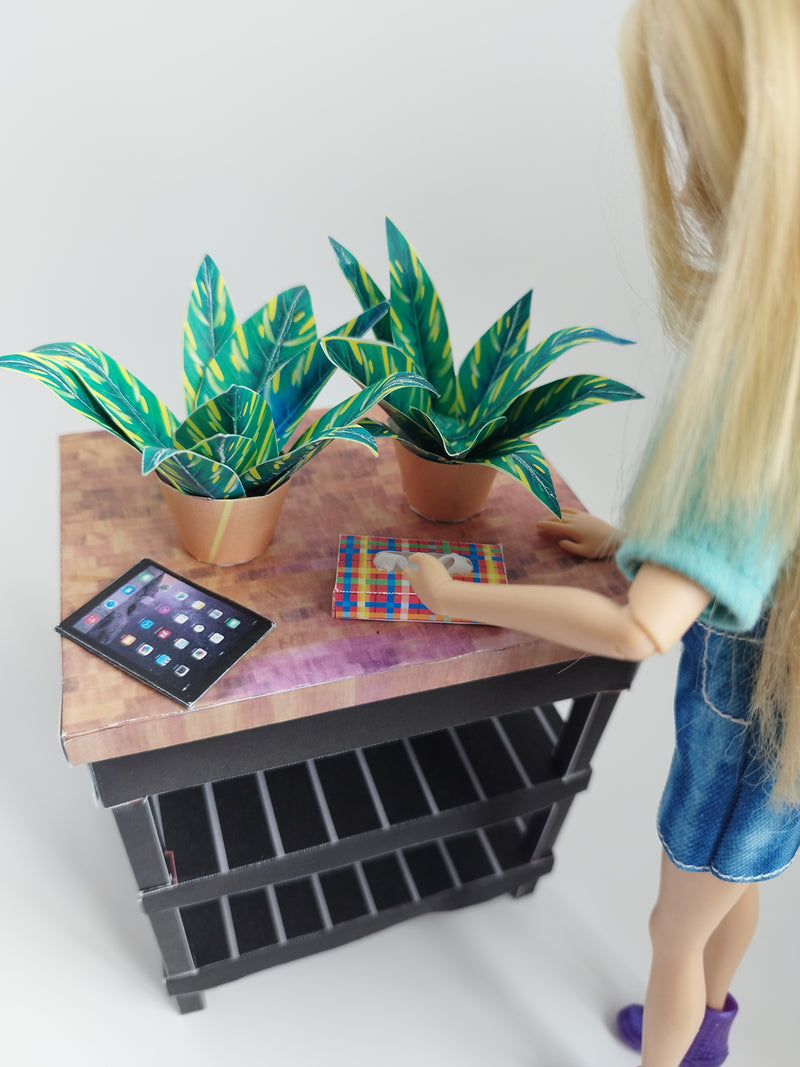 Two green and yellow patterned mini potted plants on a dollhouse table.