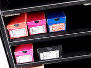 Miniature colorful shoe boxes on black shelves, some labeled 'SNEAKER' and 'SHOES'.