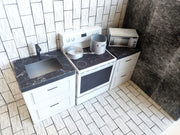 A digital printable template for a 1:12 scale dollhouse mini kitchen sink, designed for BMM system dollhouse setups. The template features a detailed, modern kitchen sink with a sleek faucet, ready to be printed on regular paper, cut, and assembled for a miniature kitchen scene.

