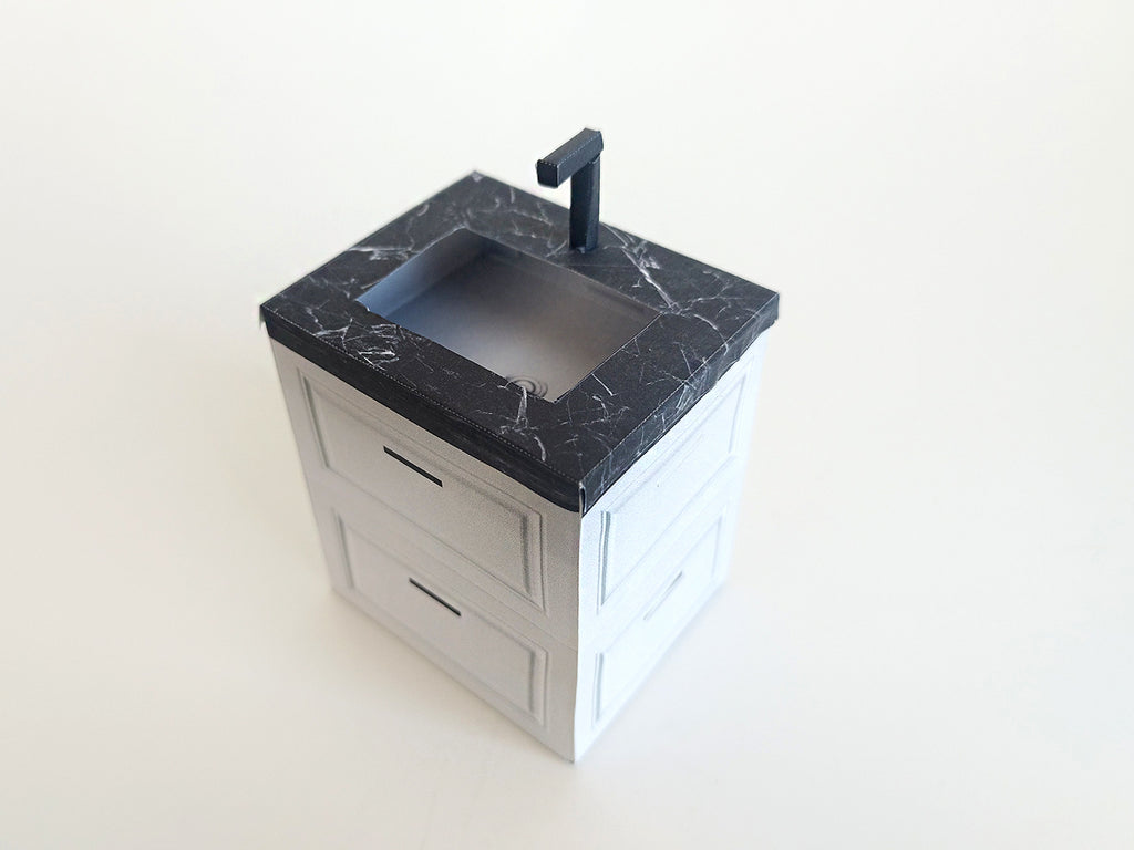 A digital printable template for a 1:12 scale dollhouse mini kitchen sink, designed for BMM system dollhouse setups. The template features a detailed, modern kitchen sink with a sleek faucet, ready to be printed on regular paper, cut, and assembled for a miniature kitchen scene.

