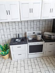 A digital printable template for a 1:12 scale dollhouse kitchen cabinet and drawer set, designed for BMM system dollhouse setups. The template features detailed, modern cabinets with drawers, ready to be printed on regular paper, cut, and assembled for a miniature kitchen scene.

