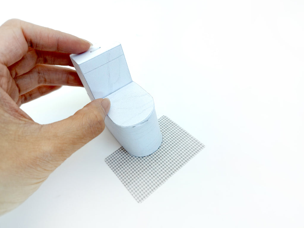 A digital printable template for a 1:12 scale dollhouse white toilet and matching carpet, designed for BMM shoe box bathroom scenes. The template includes a detailed, modern white toilet and a textured carpet, ready to be printed on regular paper, cut, and assembled for a miniature bathroom setting.

