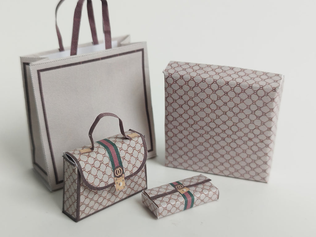 A 1:6 scale printable dollhouse set featuring four luxury brand-inspired brown shopping bags, a purse, and boxes, designed for department store or luxury home decor dioramas, ideal as yearly ornaments for miniature scenes.