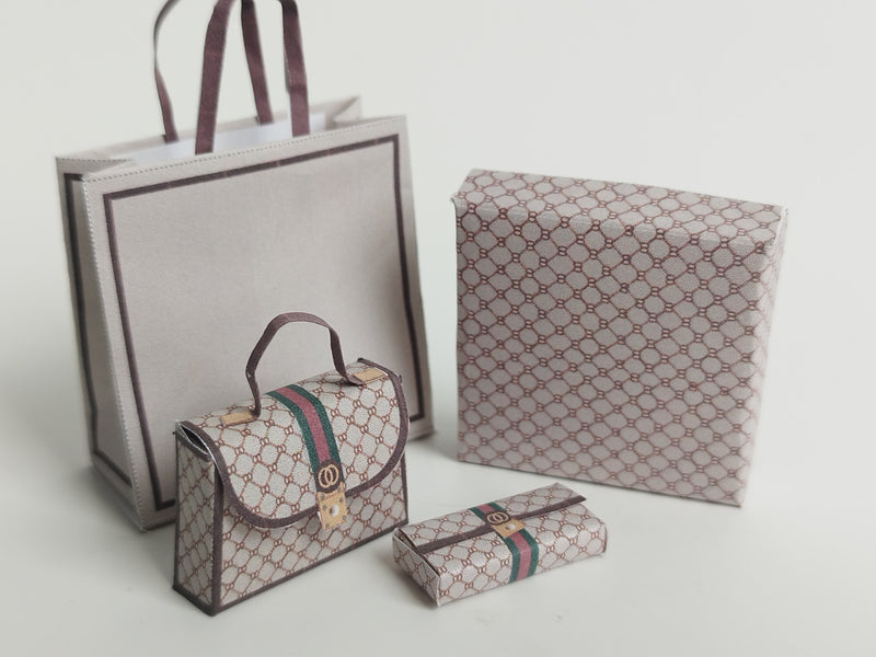 A 1:6 scale printable dollhouse set featuring four luxury brand-inspired brown shopping bags, a purse, and boxes, designed for department store or luxury home decor dioramas, ideal as yearly ornaments for miniature scenes.