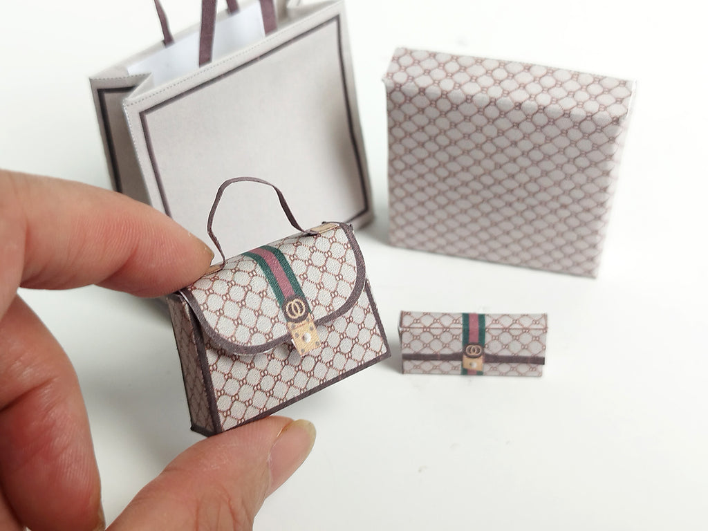 A 1:6 scale printable dollhouse set featuring four luxury brand-inspired brown shopping bags, a purse, and boxes, designed for department store or luxury home decor dioramas, ideal as yearly ornaments for miniature scenes.