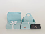 Enhance your dollhouse or department store with this 1:6 scale 5-item Sea Blue Purse and Gift Box set in black and sea blue tones. Ideal as a yearly ornament, perfect for stylish miniature displays and collectors
