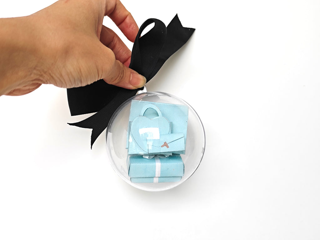 Enhance your dollhouse or department store with this 1:6 scale 5-item Sea Blue Purse and Gift Box set in black and sea blue tones. Ideal as a yearly ornament, perfect for stylish miniature displays and collectors