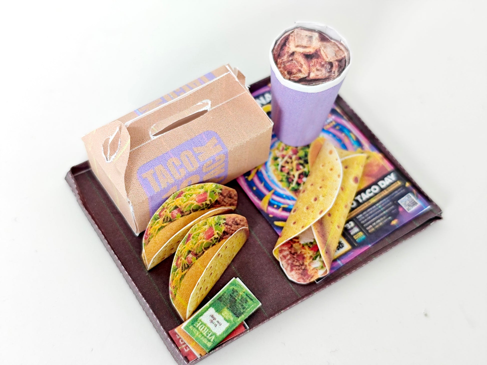 A 1:12 scale printable dollhouse fast food set featuring a taco wrap and soda, crafted as DIY templates for miniature dining scenes or yearly ornaments, ideal for detailed diorama customization.