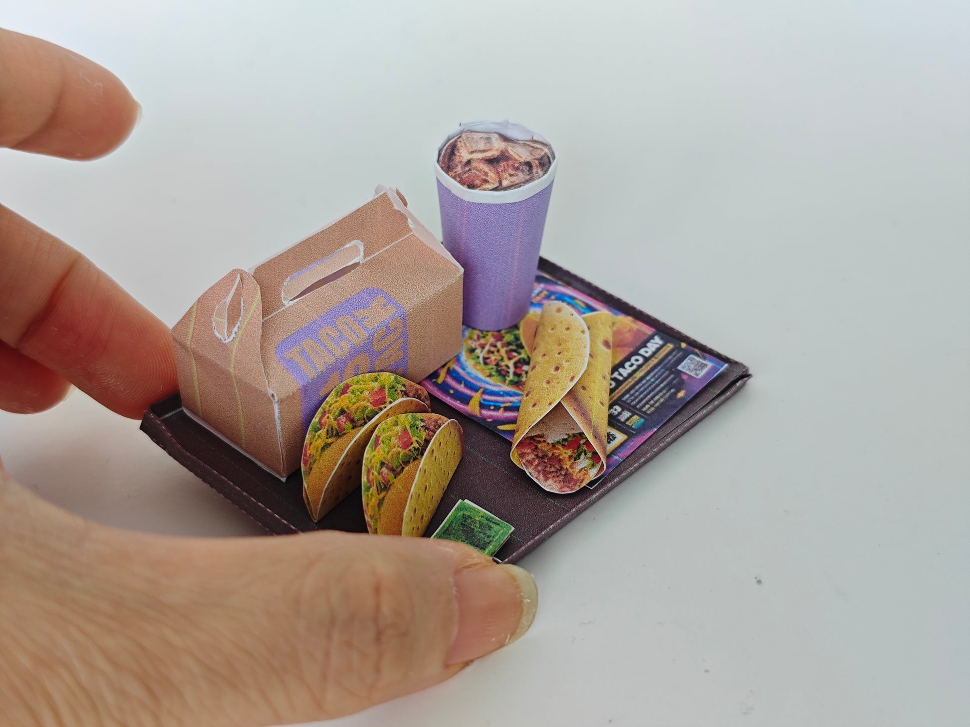 A 1:12 scale printable dollhouse fast food set featuring a taco wrap and soda, crafted as DIY templates for miniature dining scenes or yearly ornaments, ideal for detailed diorama customization.