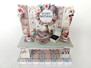 A 3D-printable STL file of a 1:12 scale vintage birthday stand DIY kit, featuring a detailed stand for displaying miniature birthday presents and cards in a dollhouse.