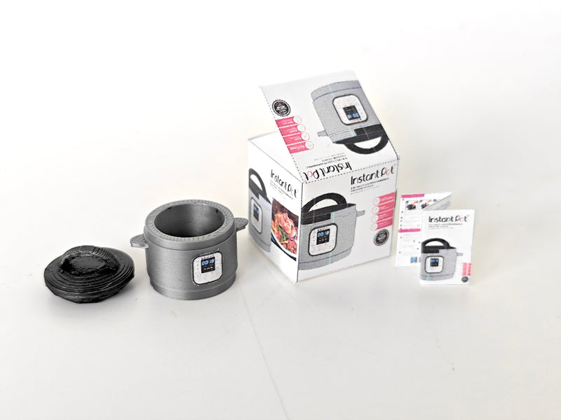 "A 3D-printable STL file of a 1:12 scale miniature Instant Pot, featuring detailed buttons and a lid for a realistic dollhouse kitchen appliance

