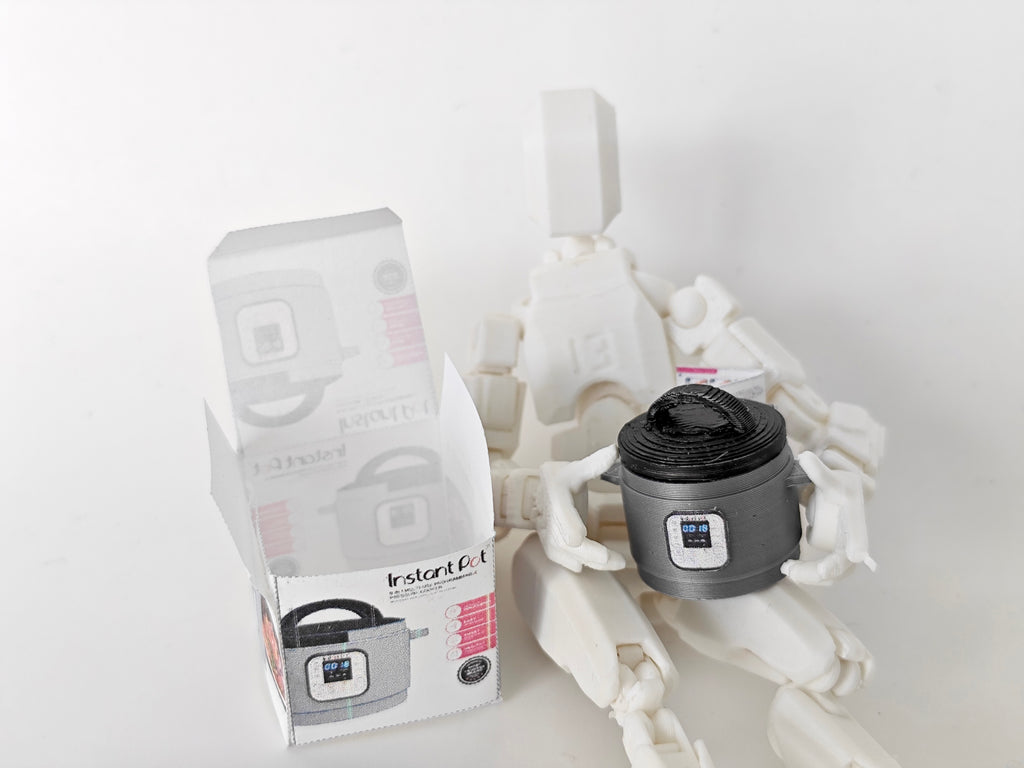 "A 3D-printable STL file of a 1:12 scale miniature Instant Pot, featuring detailed buttons and a lid for a realistic dollhouse kitchen appliance

