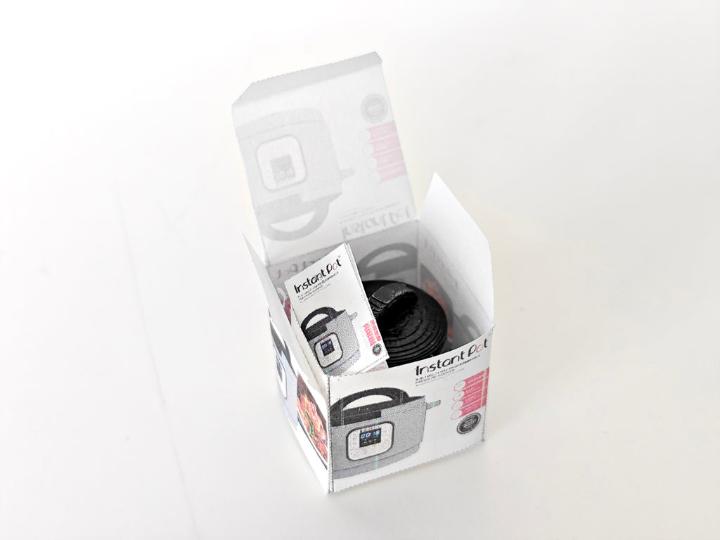 "A 3D-printable STL file of a 1:12 scale miniature Instant Pot, featuring detailed buttons and a lid for a realistic dollhouse kitchen appliance


