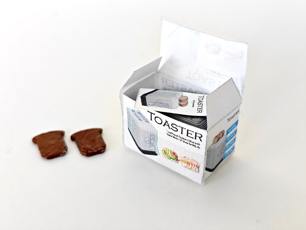 A 3D-printable STL file of a 1:12 scale miniature toaster, featuring detailed slots and buttons for a realistic dollhouse kitchen appliance