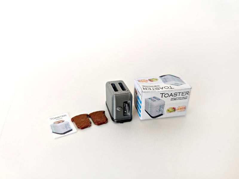 A 3D-printable STL file of a 1:12 scale miniature toaster, featuring detailed slots and buttons for a realistic dollhouse kitchen appliance