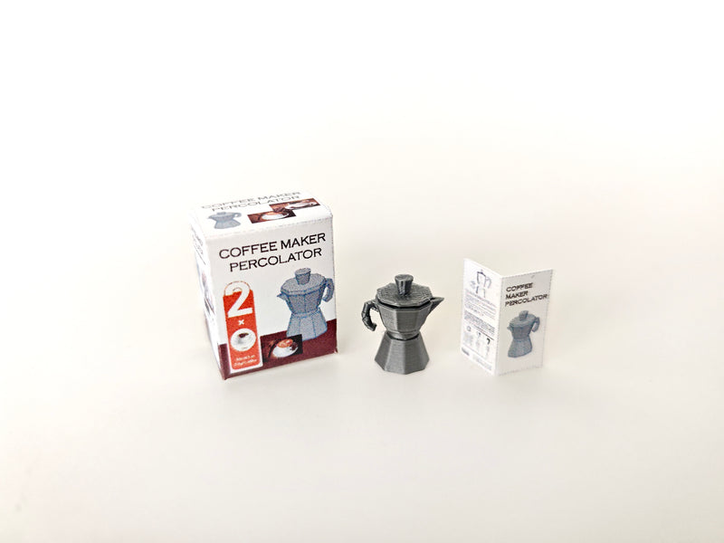 A 1:12 scale 3D-printed dollhouse coffee bar setup featuring a stove-top coffee maker, mini cookware, and a pot, with printable packaging and manual, arranged to create a detailed miniature kitchen or coffee scene for dollhouse decoration.