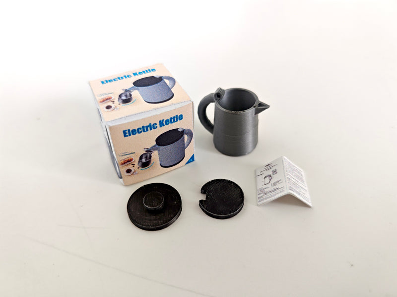 A 3D-printable STL file of a 1:12 scale miniature electric kettle with an openable lid, featuring detailed buttons and a spout for a realistic dollhouse kitchen.

