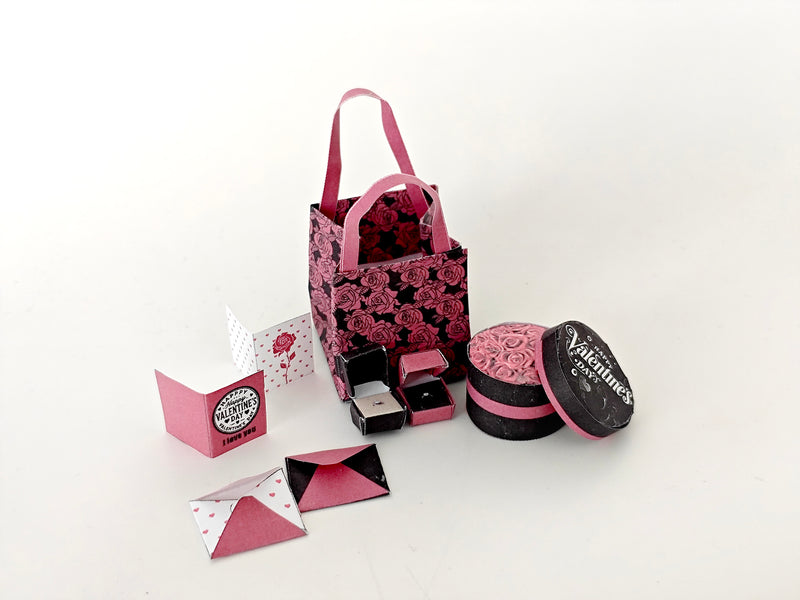 A 3D-printable STL file of a 1:6 scale Valentine’s Day gift set, featuring a flower gift box, romantic cards, rose bags, and an engagement ring, designed as charming dollhouse accessories for a miniature proposal scene or play scale display.

