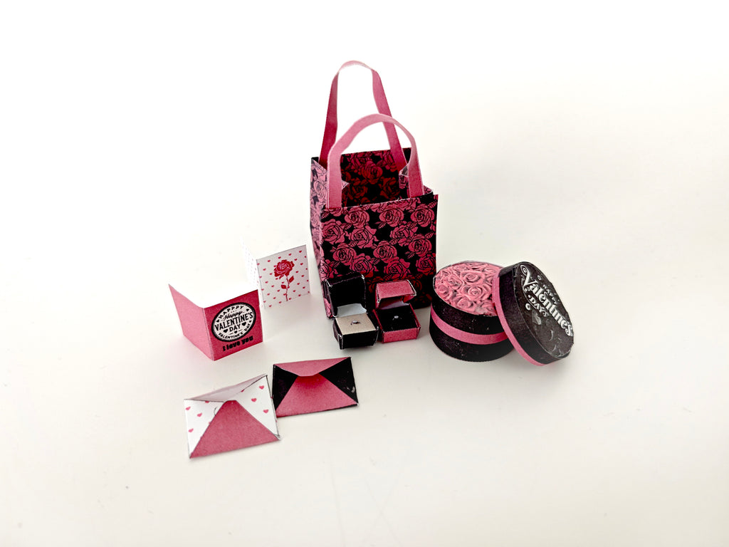 A 3D-printable STL file of a 1:6 scale Valentine’s Day gift set, featuring a flower gift box, romantic cards, rose bags, and an engagement ring, designed as charming dollhouse accessories for a miniature proposal scene or play scale display.
