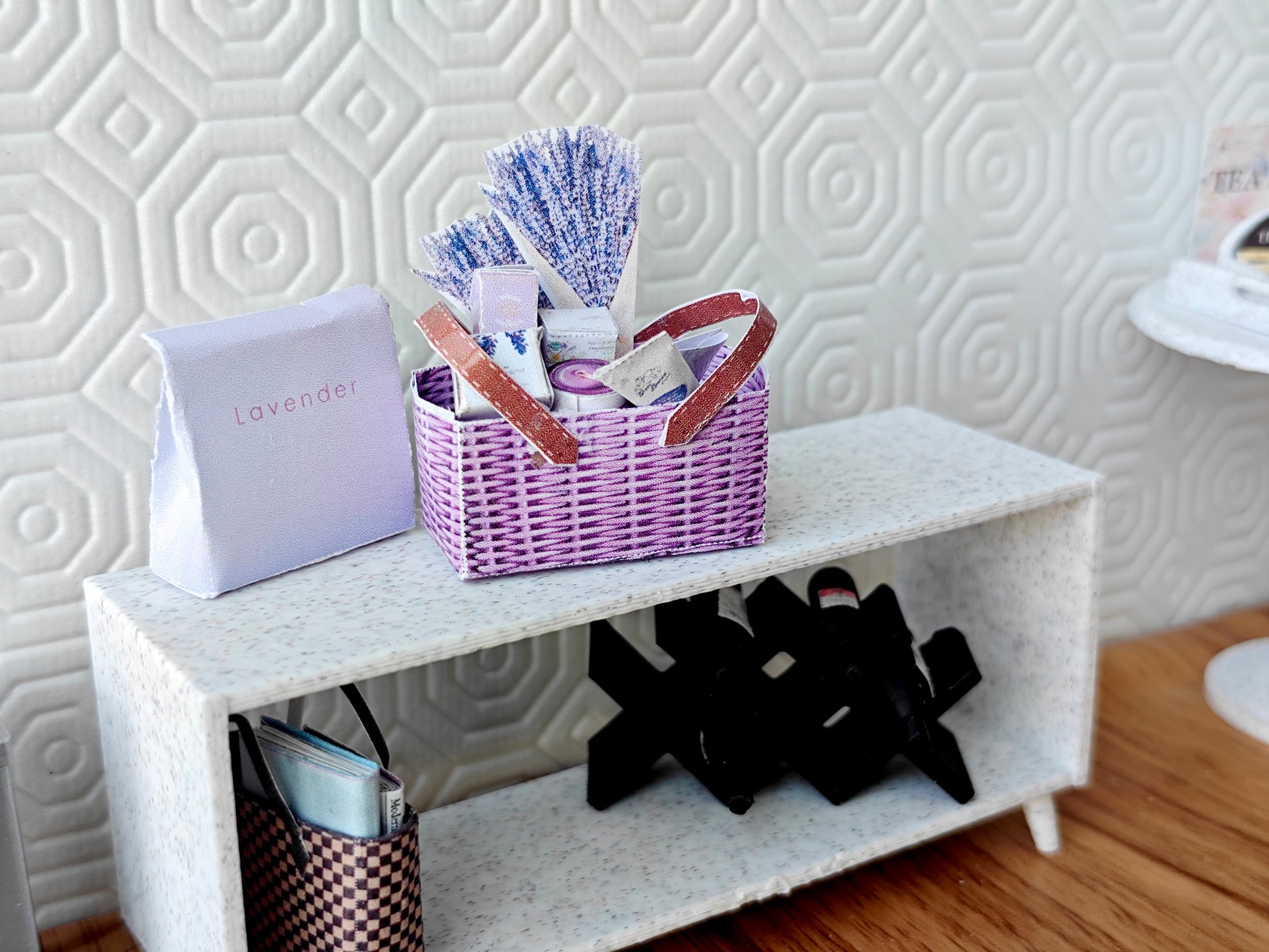Discover our 1:12 scale lavender gift basket, a charming dollhouse hamper with 11 miniature items including teas, hand cream, soaps, scented fragrance bags, and candles—perfect for a tiny spa retreat