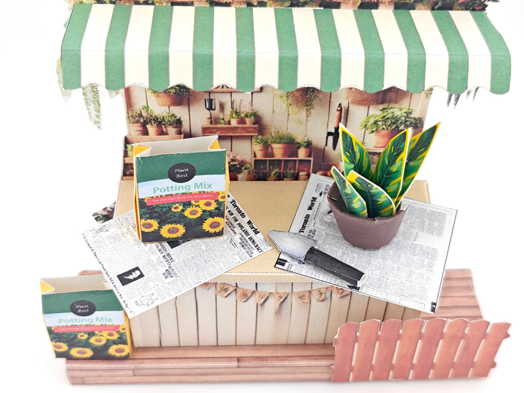 Discover the Garden Corner Miniature Stand: Create your own mini garden with plants, newspaper, potting mix, and pots. This miniature kit includes paper crafting supplies and a 7x5 frame for a charming, DIY display.
