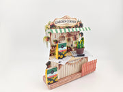 Discover the Garden Corner Miniature Stand: Create your own mini garden with plants, newspaper, potting mix, and pots. This miniature kit includes paper crafting supplies and a 7x5 frame for a charming, DIY display.