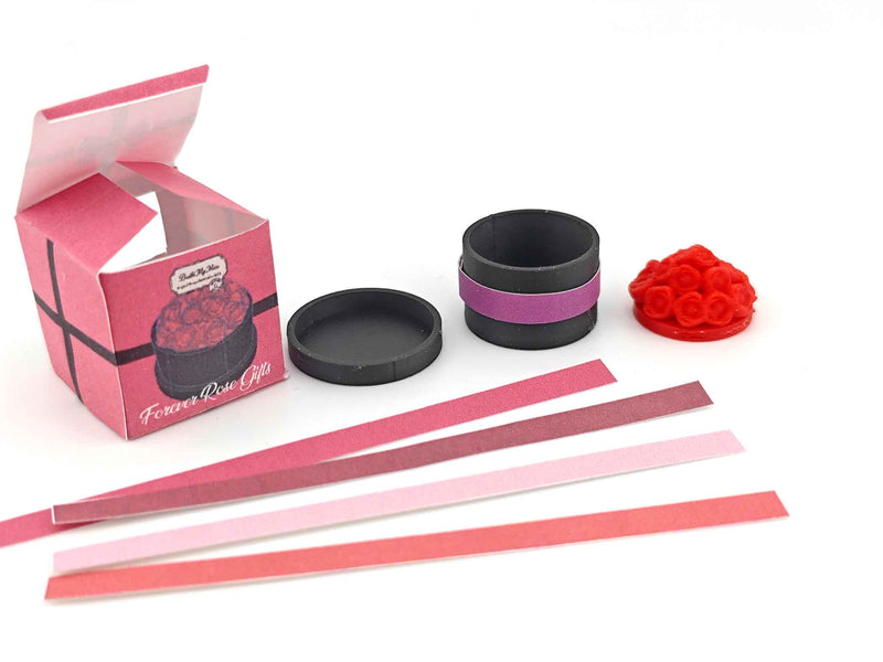 A digital rendering of a 3D printable miniature dollhouse flower box, featuring a rectangular wooden box with a grid pattern on the front. The box is accompanied by colorful strips in red, pink, and white, designed to slide into the grid for a customizable look, ideal for Mother's Day and Valentine's Day decor.