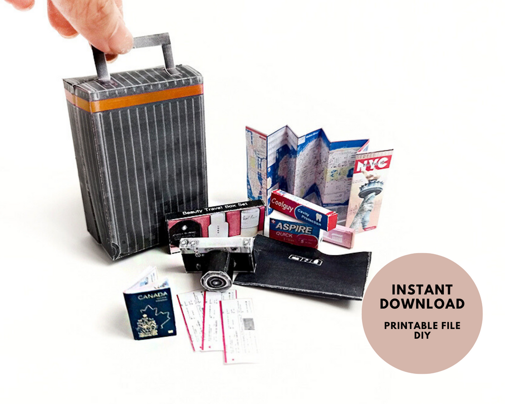 Hand holding a miniature black and orange striped suitcase with tiny travel accessories.
