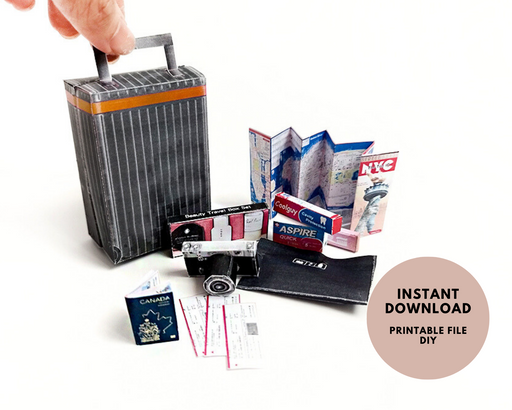Hand holding a miniature black and orange striped suitcase with tiny travel accessories.