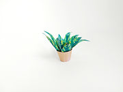 Miniature potted plant with green and yellow leaves in a light brown pot.