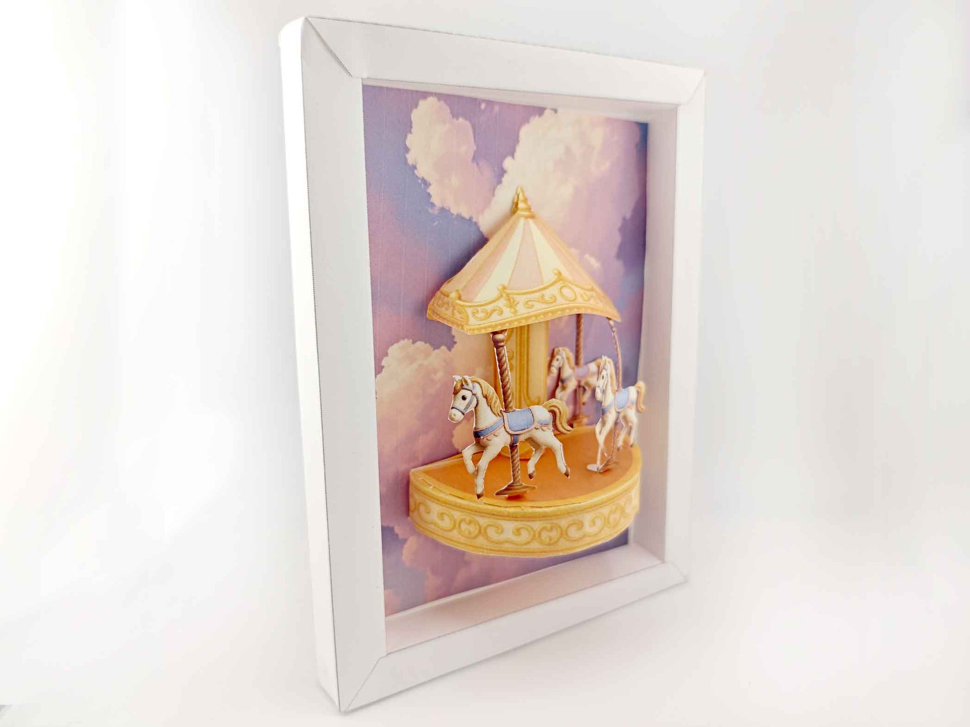 Miniature golden carousel with pink and purple fantasy sky, styled for dollhouse or decorative display