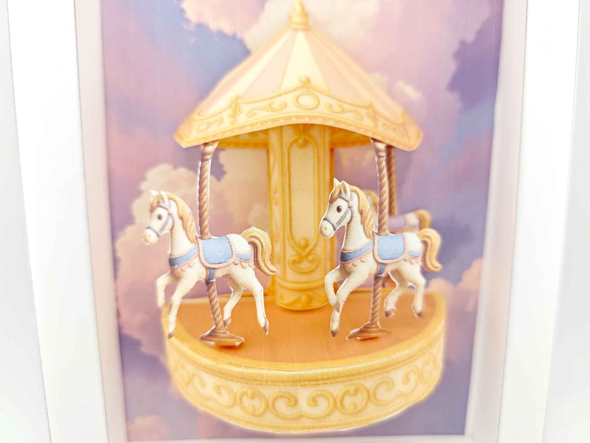 Miniature golden carousel with pink and purple fantasy sky, styled for dollhouse or decorative display