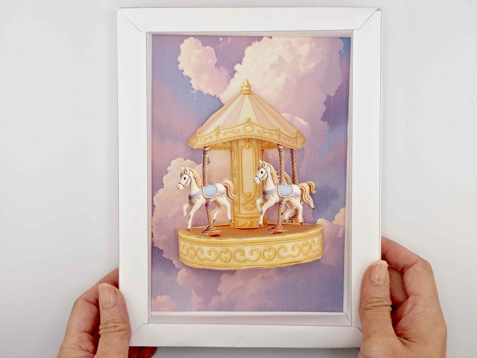 Miniature golden carousel with pink and purple fantasy sky, styled for dollhouse or decorative display