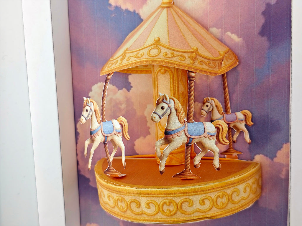Miniature golden carousel with pink and purple fantasy sky, styled for dollhouse or decorative display