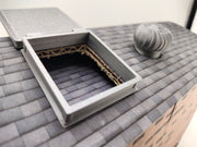 The most compelling miniature scenes rely on interactive, functional details that mirror the real world. This artist-crafted roof hatch features a fully working hinge design, allowing the textured protective lid to swing open or closed.