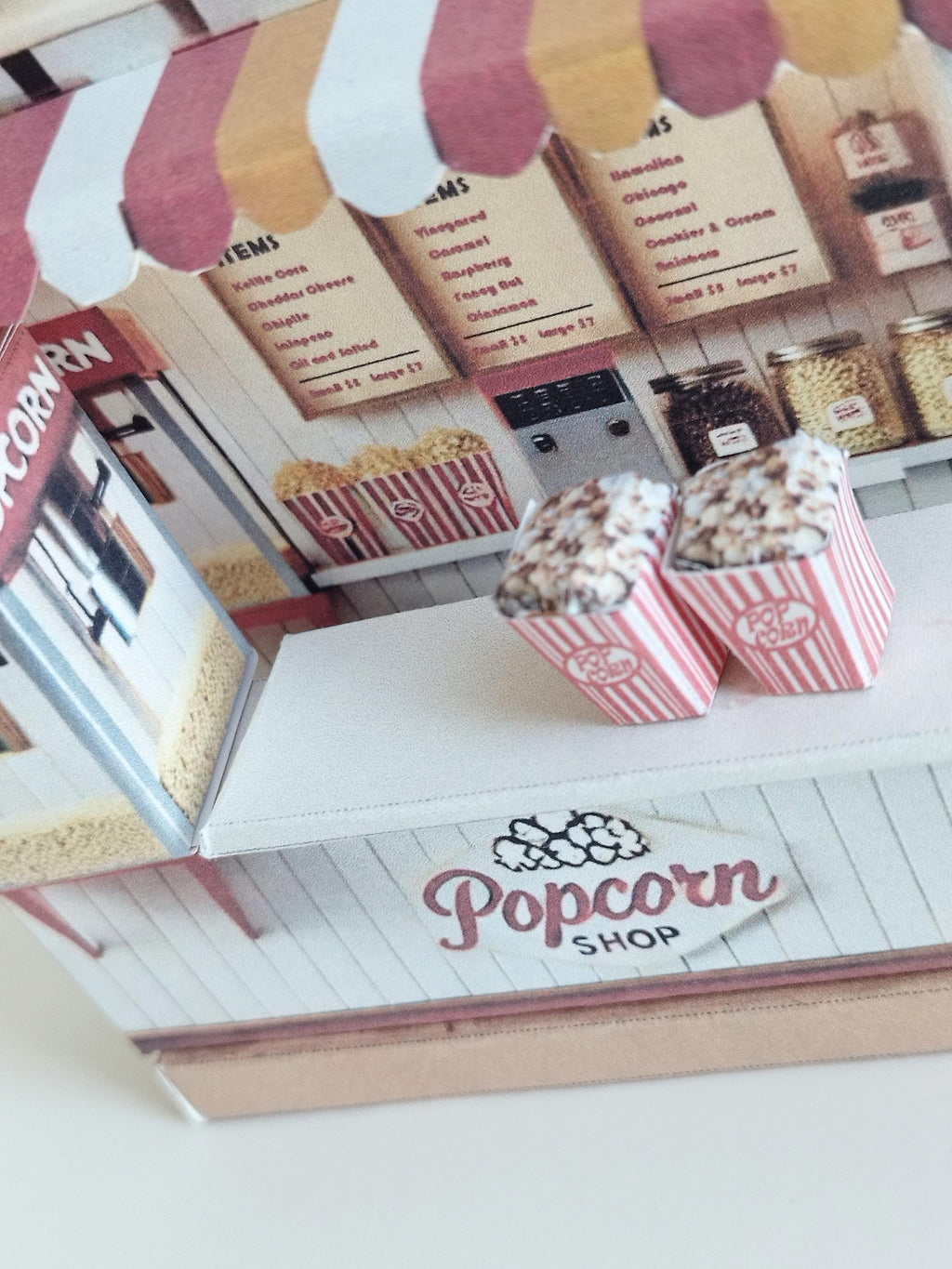 Whether as a wall decoration or a heartfelt gift, this customizable template lets you create a personalized tribute to the beauty of  Popcorn shop. This printable template brings creative 3D design to life in the form of a charming Popcorn shop miniature pop-up frame. Download and personalize it for those who appreciate the delicate. orange red color