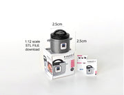 A 1:12 scale 3D-printed dollhouse kitchen setup featuring an Instant Pot, mini cookware, and a pot, with a printable box and manual, arranged to create a detailed miniature cooking scene for diorama or dollhouse enthusiasts.