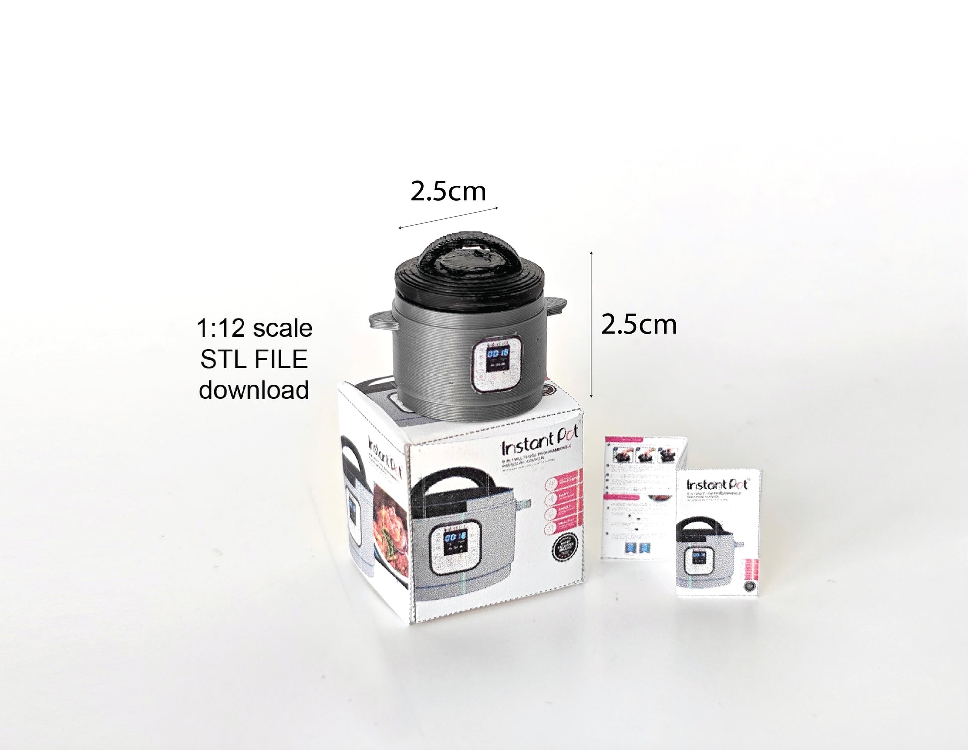 A 1:12 scale 3D-printed dollhouse kitchen setup featuring an Instant Pot, mini cookware, and a pot, with a printable box and manual, arranged to create a detailed miniature cooking scene for diorama or dollhouse enthusiasts.