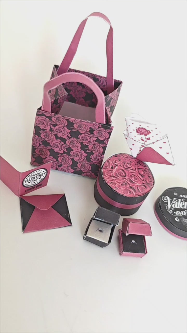 A 3D-printable STL file of a 1:6 scale Valentine’s Day gift set, featuring a flower gift box, romantic cards, rose bags, and an engagement ring, designed as charming dollhouse accessories for a miniature proposal scene or play scale display.
